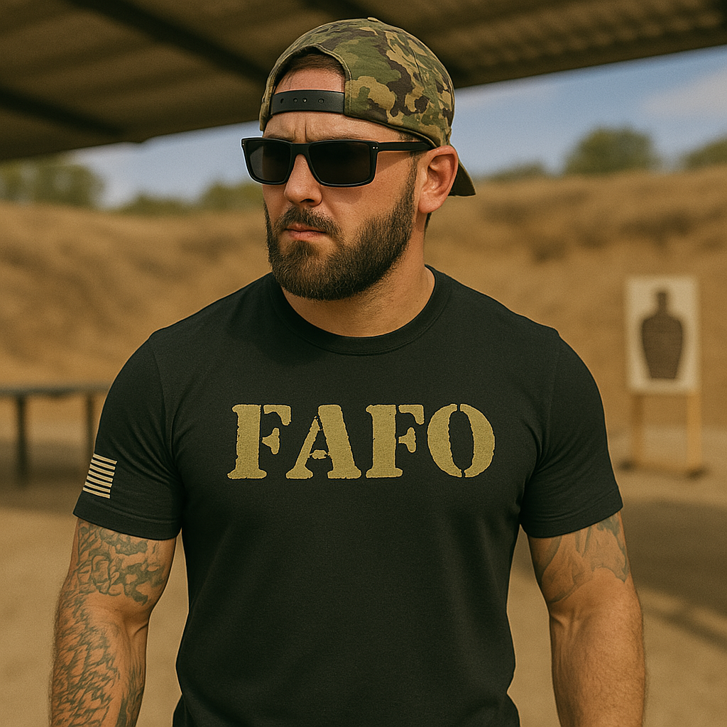 Tattooed muscular man wearing a black FAFO t-shirt, camo baseball cap, and sunglasses at an outdoor shooting range